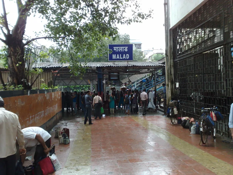 Malad red light area, Mumbai — the monsoon-wet west entrance of Malad station in the lodge belt