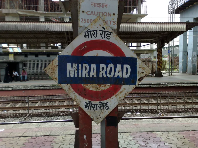 Mira Road red light area, Mumbai — the weathered station nameboard on the Mira Road platform