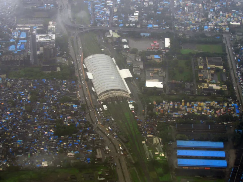 Turbhe — Turbhe Tekdi red light area, Mumbai — aerial view of Turbhe station's arched roof amid the MIDC-belt sprawl
